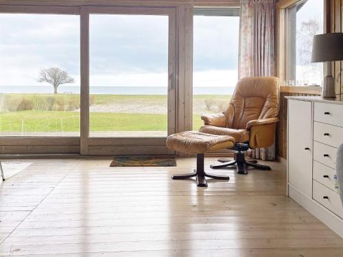 uma sala de estar com uma cadeira e uma grande janela em Holiday home Præstø II em Praesto