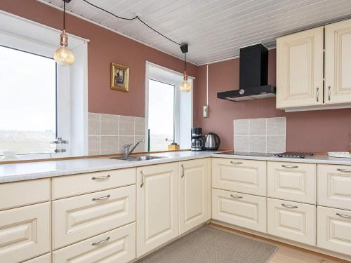 una cocina con armarios blancos y fregadero en 6 person holiday home in Harbo re en Harboør