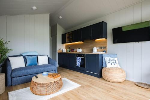克利索普斯的住宿－Lowfield Lodge & Hot Tub - Humberston Fitties Beach，客厅配有蓝色的沙发和桌子
