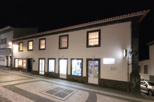 a white building with a lot of windows at night at Apartamentos Ázera - Lígia Ázera in Praia da Vitória