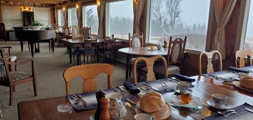 a restaurant with tables and chairs and a large window at Amherst Shore Country Inn in Lorneville