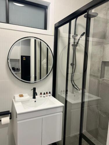 a bathroom with a shower and a sink and a mirror at Northcott Lodge in Adamstown