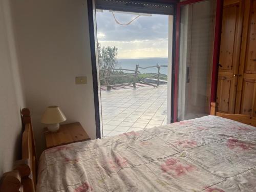 um quarto com uma cama e vista para o oceano em Villa del sole em Magomadas
