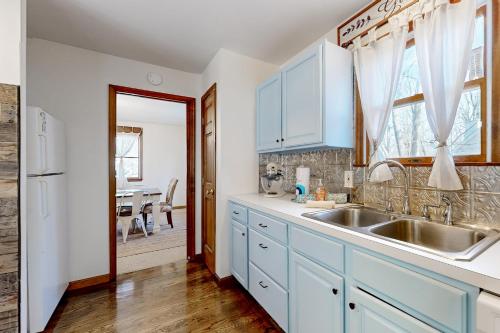 a kitchen with white cabinets and a sink at Postcard Pines in Jim Thorpe