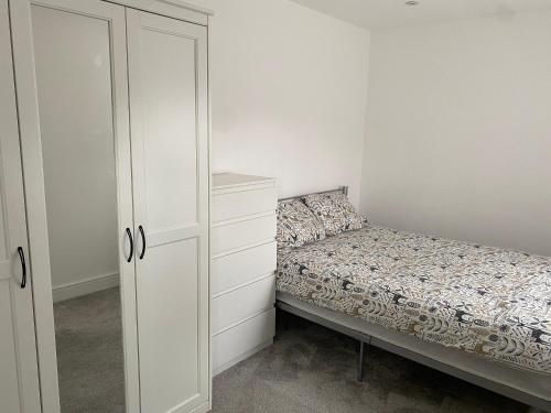 a small bedroom with a bed and a dresser at Your perfect place of comfort in Goodmayes
