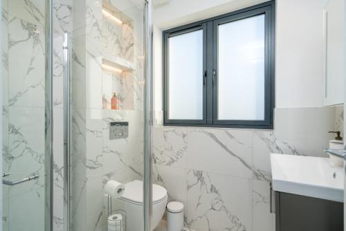 ein Bad mit einer Dusche, einem WC und einem Waschbecken in der Unterkunft Stylish One bedroom Flat near Kingsbury Station in Wealdstone