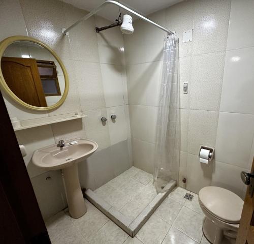 a bathroom with a sink and a shower with a mirror at Departamento con baño privado in Sucre