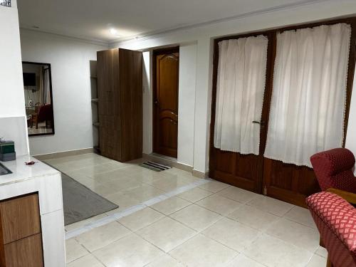 a living room with wooden doors and a tile floor at Departamento con baño privado in Sucre