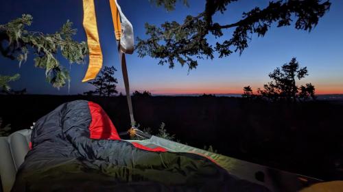 a tent is set up with a sunset in the background at Tree Climbing at Silver Falls in Sublimity