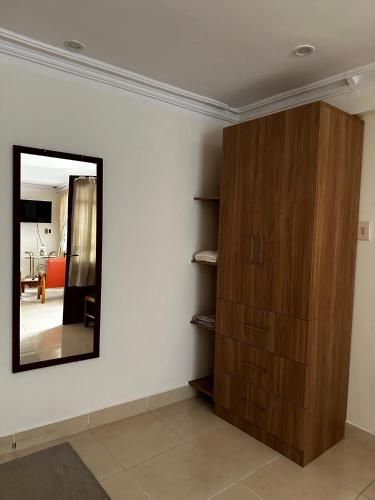 a room with a mirror and a wooden cabinet at Departamento con baño privado in Sucre
