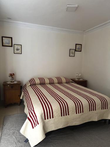 a bedroom with a bed with a striped blanket at Departamento con baño privado in Sucre