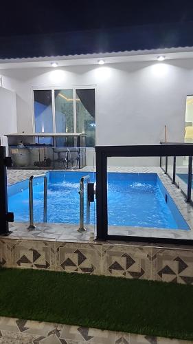 ein Schwimmbad in der Mitte eines Hauses in der Unterkunft شاليهات الشموخ محايل عسير in Muhayil