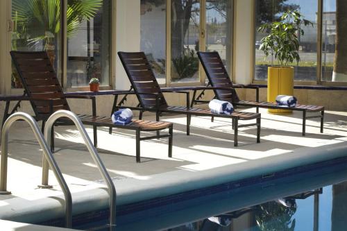 a group of chairs sitting next to a swimming pool at voco Saltillo Suites by IHG in Saltillo