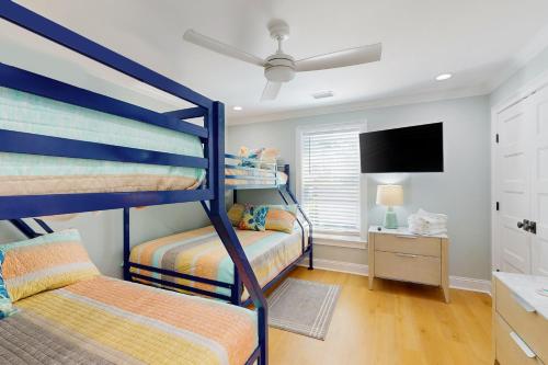 1 dormitorio con 2 literas y TV de pantalla plana en Seabirds, en Sunset Beach