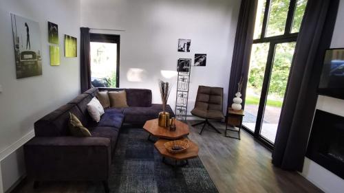 sala de estar con sofá y mesa en Strand & Veluwemeer - Cube Elite Premium Bad Hoophuizen en Hulshorst