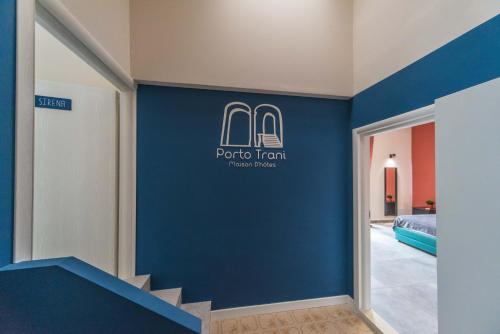 a hotel room with a blue accent wall at Porto Trani Maison D' Hòtes in Trani