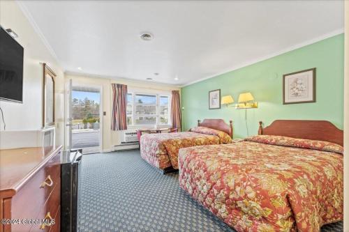 ein Hotelzimmer mit 2 Betten und einem TV in der Unterkunft Top Hill Motel in Saratoga Springs