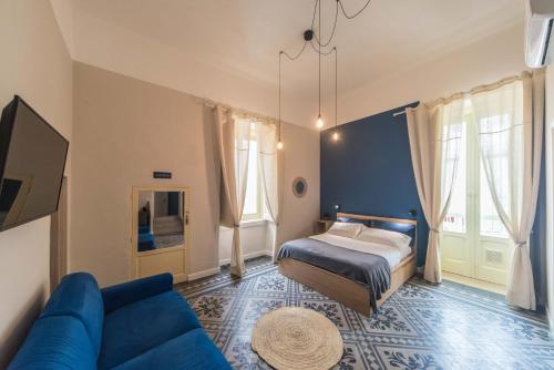 - une chambre avec un lit et un canapé bleu dans l'établissement Porto Trani Maison D' Hòtes, à Trani