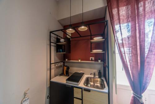eine kleine Küche mit einem Waschbecken und einem Fenster in der Unterkunft Porto Trani Maison D' Hòtes in Trani