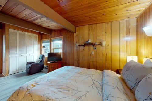 a bedroom with a bed and a chair in a room at Sands End in Yachats