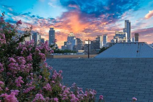 vistas al perfil urbano al atardecer con flores púrpuras en 2BR Designer Penthouse Suite on Trendy East 11th St, Downtown Austin, en Austin