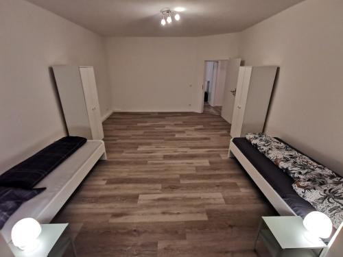 an empty room with two beds and two tables at Modern Apartment Gelsenkirchen in Gelsenkirchen