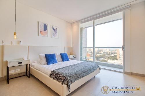 1 dormitorio con cama y ventana grande en Distrito 90 - Estudios y Apartamentos para vacaciones y viajes de negocio, en Barranquilla