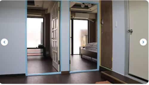 a room with two open doors and a bedroom at Sophiearth Apartment in Tokyo