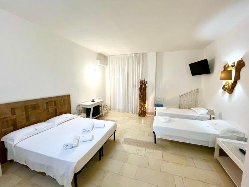 een hotelkamer met 2 bedden en een televisie bij Salto Nel Blu in Leverano