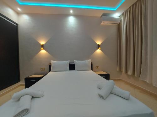 a bedroom with a large white bed with blue lights at borj rayhane 1 in Tangier