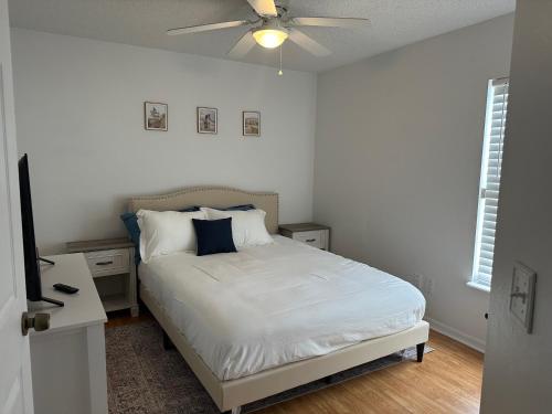 1 dormitorio con 1 cama y ventilador de techo en Adv. Coast: 4/2, Near Springs, Beach, Big Fenced Yard, en Spring Hill
