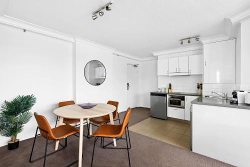 布里斯本的住宿－1-Bed Brisbane City Pad with Sweeping Views，厨房以及带桌椅的用餐室。
