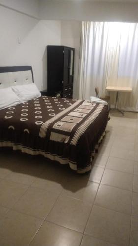 a large bed in a room with a table at Hotel Real Doxey in Tlaxcoapan