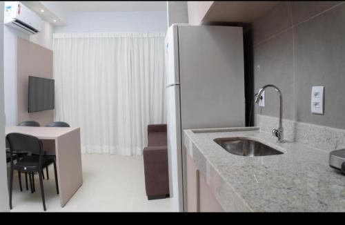 a kitchen with a sink and a refrigerator at Lagoa Eco Towers Resort in Caldas Novas