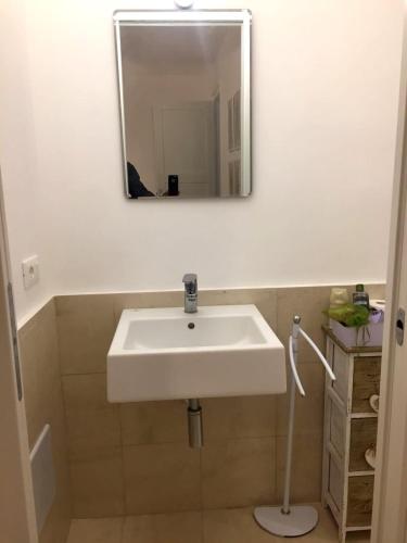 La salle de bains est pourvue d'un lavabo blanc et d'un miroir. dans l'établissement Love Trapani Torre Carosio, à Trapani