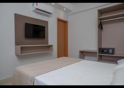 a bedroom with a bed and a flat screen tv at Lagoa Eco Towers Resort in Caldas Novas