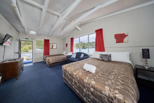 a hotel room with two beds and a television at Sea View Motel - Unit 1 in Kaikoura
