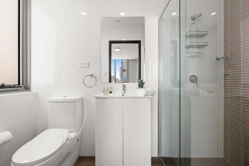 a white bathroom with a toilet and a sink at Central 2-Bed with Parking & Stunning Views in Sydney