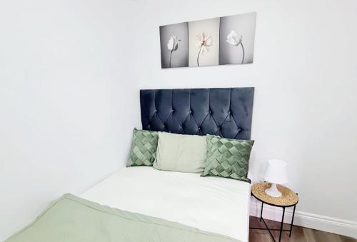 a bedroom with a bed with a blue headboard at Modern Luxurious New Build Entire 2 Bedroom Apartment in Basildon