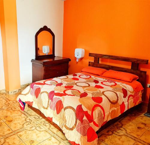 - une chambre avec un lit, une commode et un miroir dans l'établissement Hostal La Cocha, à Latacunga