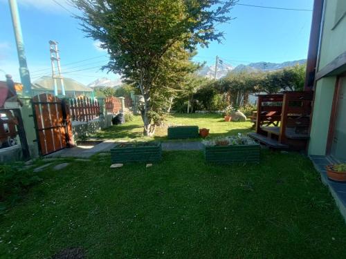 a yard with green chairs in the grass at BZ Apartment in Ushuaia