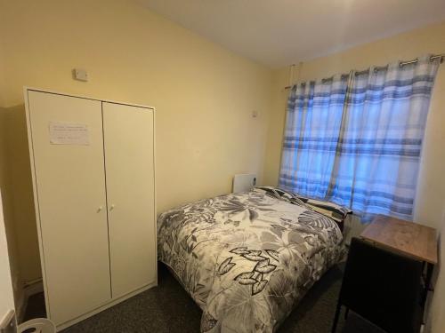 a bedroom with a bed and a cabinet and a window at Private double rooms near City centre, Coventry with free Parking/WiFi in Coventry