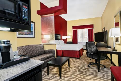 une chambre d'hôtel avec un lit et un salon dans l'établissement Holiday Inn Express & Suites Cotulla, an IHG Hotel, à Cotulla