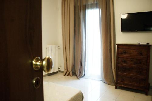 1 dormitorio con ventana, vestidor y TV en GuesthouseAntonia, en Avellino
