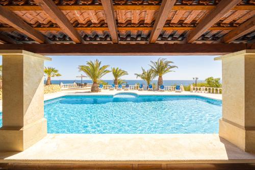 - une piscine avec l'océan en arrière-plan dans l'établissement Stunning Villa Carichel Blanc, à La Vila Joiosa