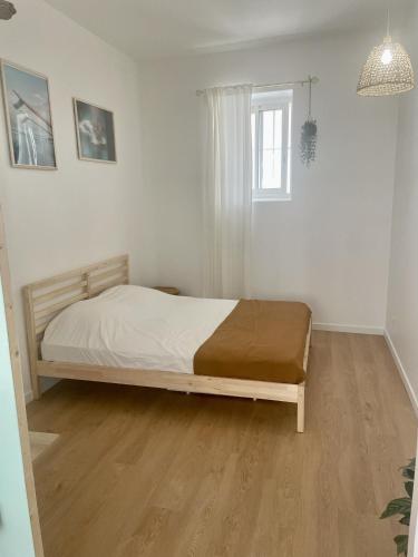 une chambre avec un lit dans une pièce blanche dans l'établissement Confort & Calme - Proche de la mer, métro, centre ville et stade, à Marseille