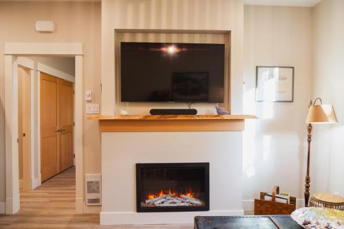 a living room with a fireplace with a tv above it at Cowichan Valley Guest Cottage in Ladysmith