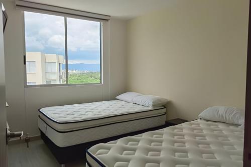 - 2 lits dans une chambre avec fenêtre dans l'établissement Apto completo Pto Azul Club House Ven a Descansar, à Ricaurte