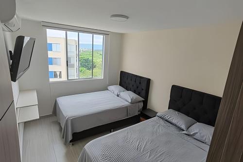 a bedroom with two beds and a window at Apto completo Pto Azul Club House Ven a Descansar in Ricaurte