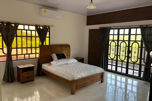 a bedroom with a bed and two large windows at Hermosa finca plan ecológico Brisas de 4 Esquinas in Carmen de Apicalá